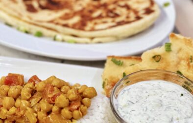 Flavorful Chickpea Curry Feast: Spice Up Your Mealtime with Naan Bread and Refreshing Cucumber Raita
